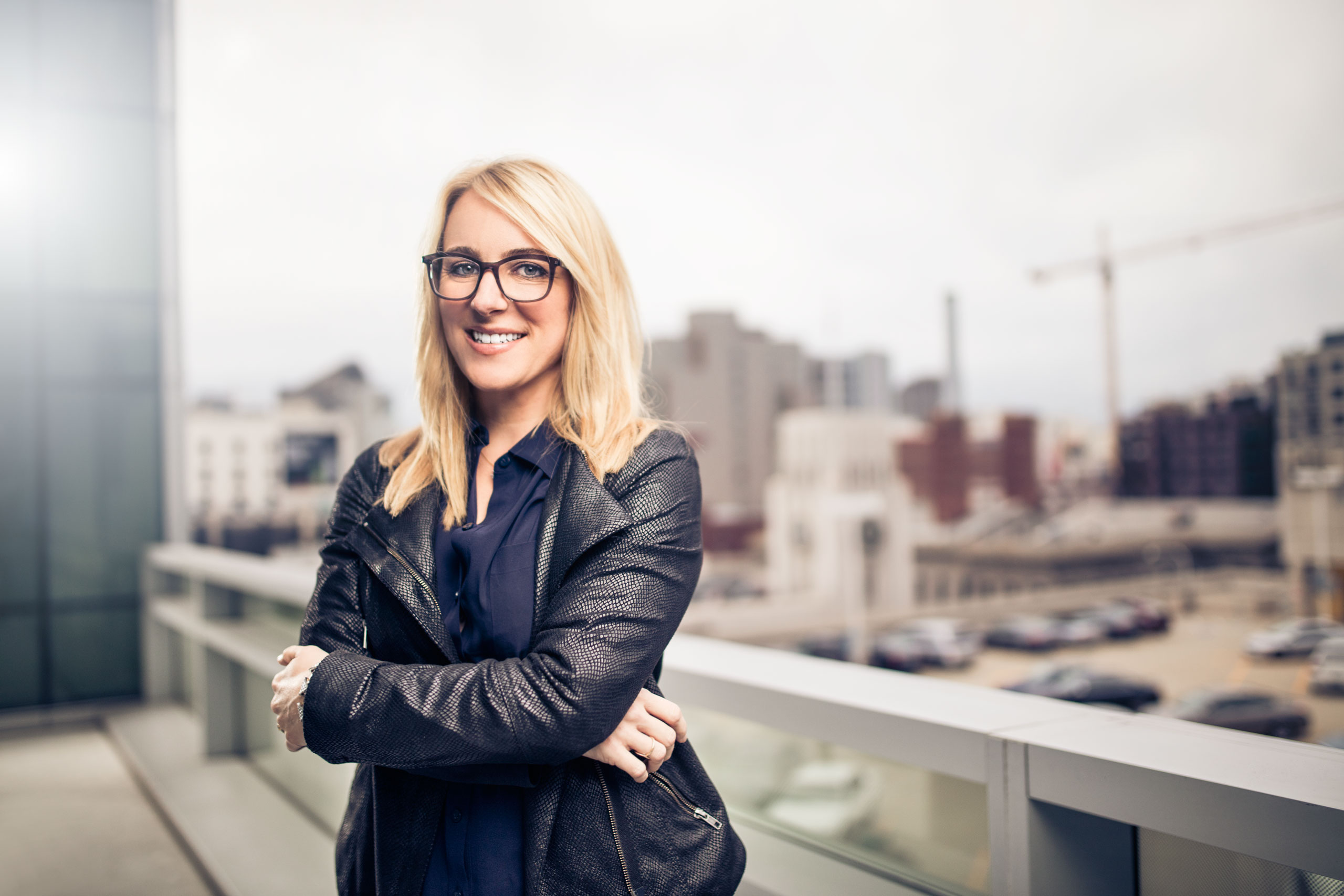 Photo of April Underwood standing on a balcony with arms crossed