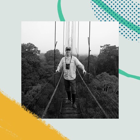Black and white photo where a man is walking on a rustic bridge in nature